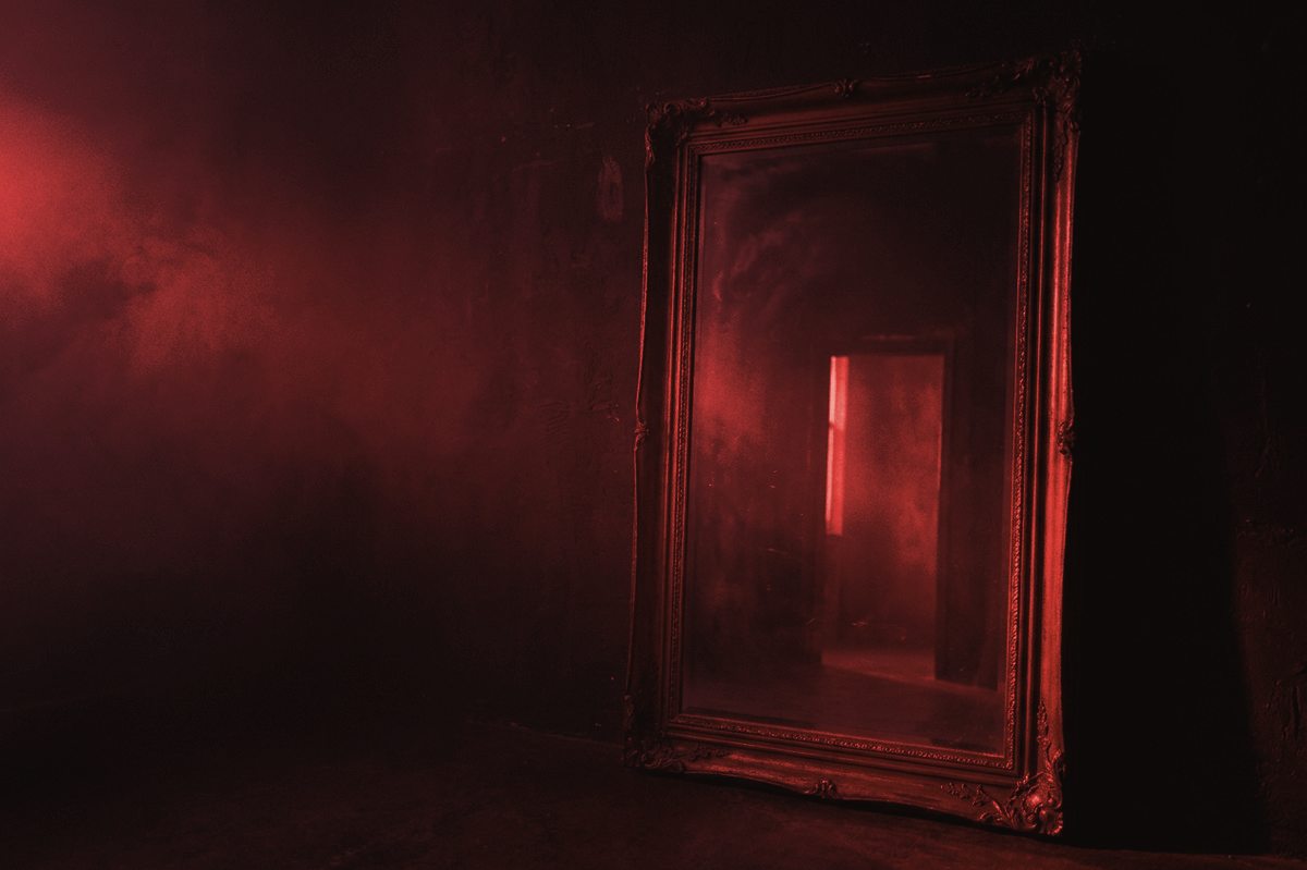 An antique mirror leaning against a dark wall